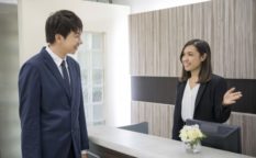 受付で笑顔の対応を受けるスーツ姿の営業マン｜法人向け飛び込み営業シーン