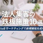 会議資料を囲むビジネスパーソンの手元と「法人集客の鉄板施策10選｜BtoBマーケティングで新規開拓を成功に」という日本語テキストが重なる画像